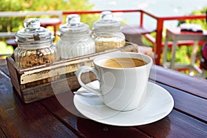 Cup of Coffee on table over mountains landscape with sunlight