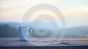 Cup with coffee on table over mountains landscape