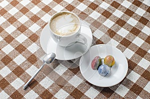 A cup of coffee on a table with sweets