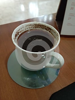 a cup of coffee on the table to get rid of sleepiness photo