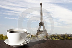 Cup of coffee on the table with view of Eiffel tower in Paris