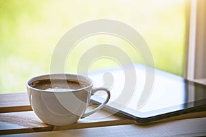 Cup of coffee with tablet computer