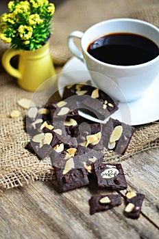 Cup of coffee and tasty cookie on wooden background.