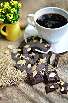 Cup of coffee and tasty cookies on wooden background.