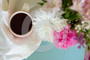 Cup of coffee tea with multicolor bouquet of flowers