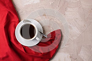 Cup of coffee or tea red napkin concrete background