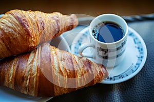 Cup of coffee with two croissants