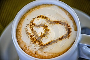 Cup of coffee with two hearts. It s symbol of Love in foam