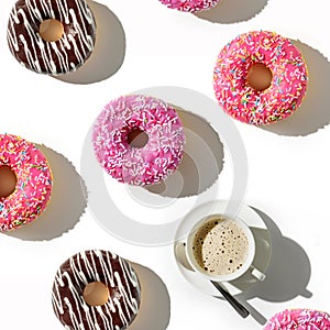 A cup of coffee and a variety of donuts on a white background. Flat lay composition with coffee and donuts