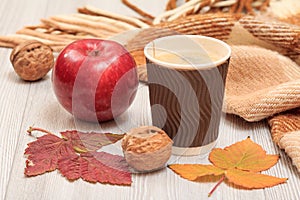 Cup of coffee, walnut, apple and dry leaves in an autumn still llife
