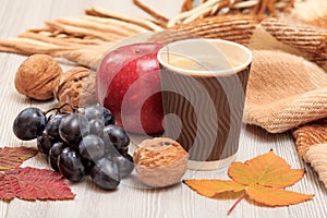 Cup of coffee, walnut, grapes, apple and dry leaves in an autumn still llife