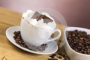 Cup of coffee with whipped cream and chocolate