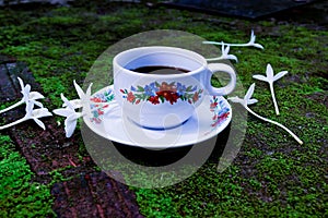 Cup of coffee and white flower