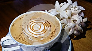 Cup of coffee and white flowers on wood in night