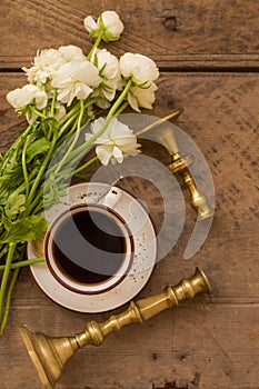 A cup of coffee and white ranunculus