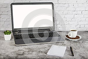 A cup of coffee on a white table with a laptop, notepad and pen. Mock up business concept. Place for your text.