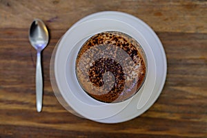 A cup of coffee on a wood table.