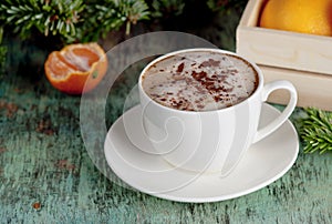A cup of coffee on a wooden background. Coffee cappuccino with Christmas fir branches and ornaments on old wooden background