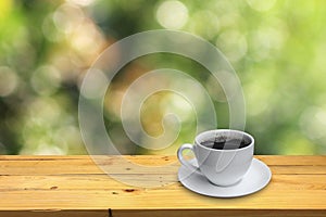 Cup of coffee on the wooden floor and bokeh background