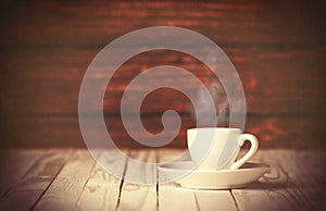 Cup of coffee on wooden table and background.