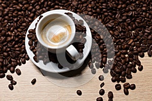 Cup of coffee on a wooden table with coffee beans photo