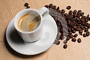 Cup of coffee on a wooden table with coffee beans photo