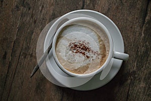 A cup of coffee in the wooden table. photo