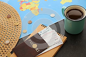 Cup of coffee, world map and passport with air tickets on table. Travel concept