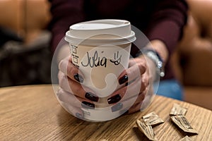 Cup of coffee with writen word JULIA in woman hand photo