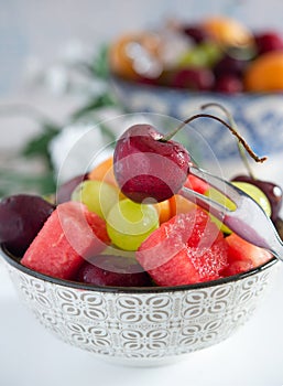 cup with cold water and fresh summer fruit with ice