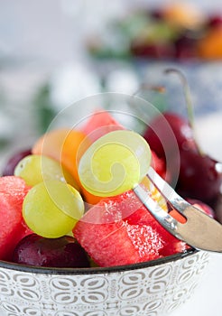 cup with cold water and fresh summer fruit