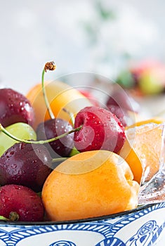 cup with cold water and fresh summer fruit