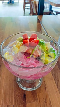 A cup of colorful mixed ice with fresh fruit pieces ordered at a cafe in Indonesia