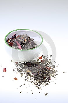 Cup containing green aromatized tea on a white background