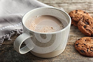 Cup with delicious hot cocoa drink and cookies