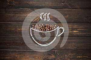 cup drawn with chalk on the old vintage wooden board. Coffee beans.