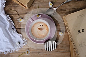 cup with drink coffee cappuccino and foam in smile form on old vintage wooden table, caffeine improves functioning of human brain