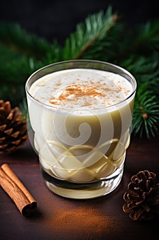 Cup of Eggnog or egg milk punch Christmas traditional drink with spices on wood table