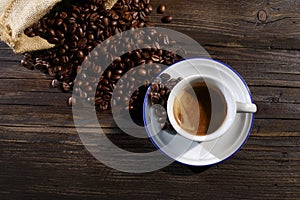 Cup of espresso with coffee beans close photographed from above