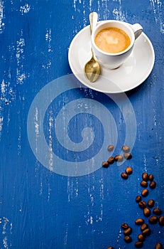 Cup of espresso coffee and beans on wooden blue painted table