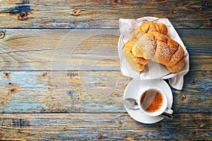 Cup of espresso coffee and brioche on an old wooden table