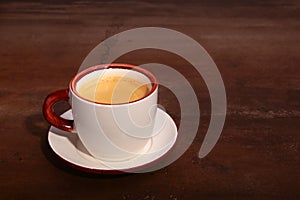 A cup of espresso coffee on a dark wooden background