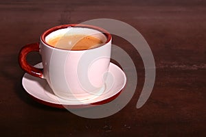 A cup of espresso coffee on a dark wooden background