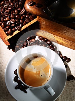 Cup of espresso coffee, old grinder and beans