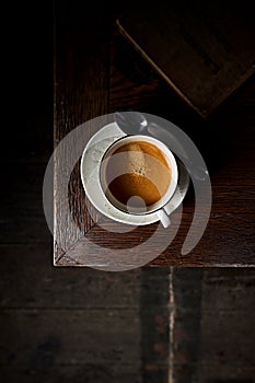 Cup of espresso coffee on an old wooden table. Top view