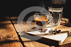 A cup of espresso and cold water on the old wooden table