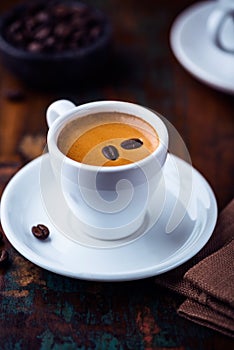 Cup of espresso crema with coffee beans