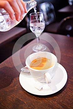 Cup of espresso and pouring water