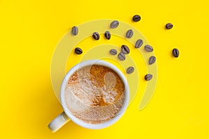 Cup of espresso and roasted coffee beans, top view