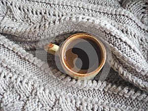 A Cup of espresso in a winter sweater. The concept of home comfort, coziness and warmth.